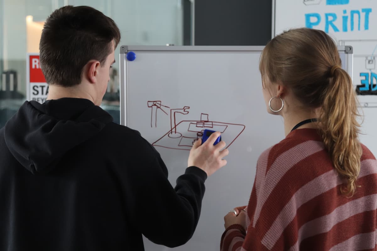 Whiteboarding the robotic arm design at HACK@URI